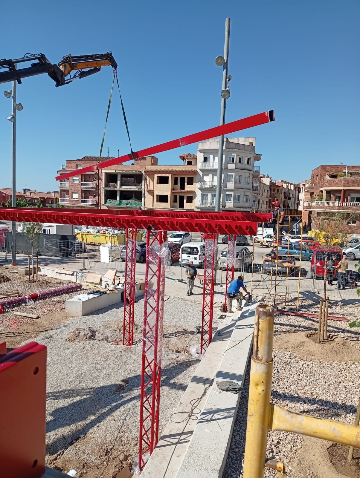 Estructura de acero rojo con pilares montada en una plaza