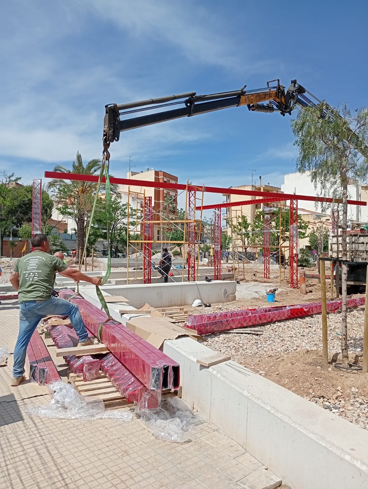 Operario preparando vigas de acero para el izado con grúa